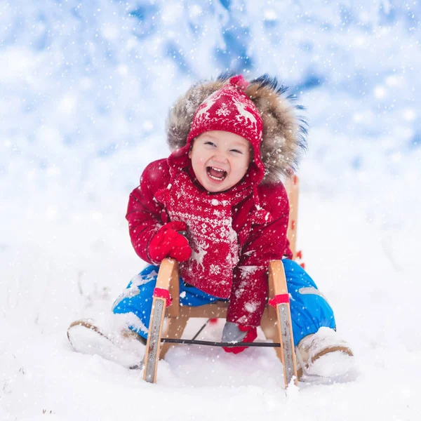 Los niños juegan en la nieve. Paseo en trineo de invierno para niños —  Fotos de Stock