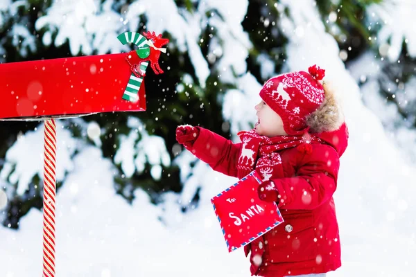 Bambino con lettera a Babbo Natale cassetta postale in neve — Foto Stock