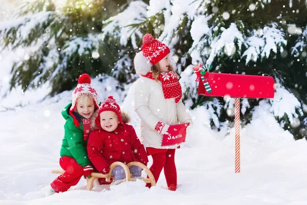 Niños con carta a Santa en el buzón de Navidad en nieve —  Fotos de Stock