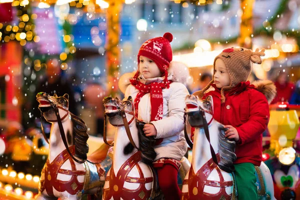 Children riding carousel on Christmas market — Stock Photo, Image