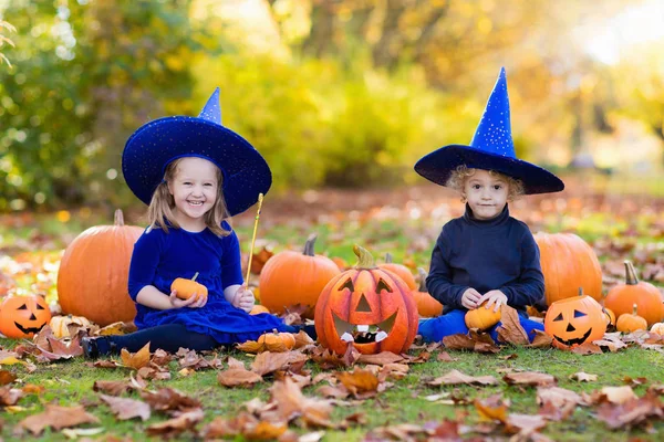 Crianças com abóboras em trajes de Halloween — Fotografia de Stock