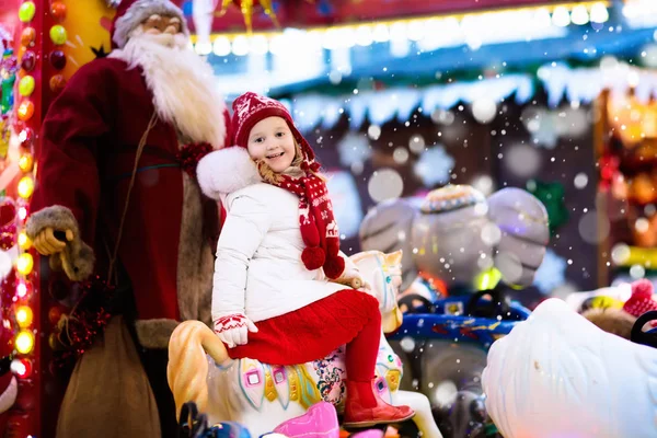 Child on Christmas fair. Kid riding Xmas carousel — Stock Photo, Image