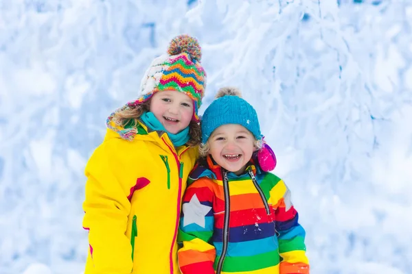 Barnen leker med snö i vinter park — Stockfoto