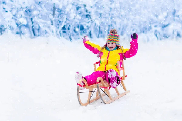 As crianças brincam na neve. Passeio de trenó de inverno para crianças — Fotografia de Stock