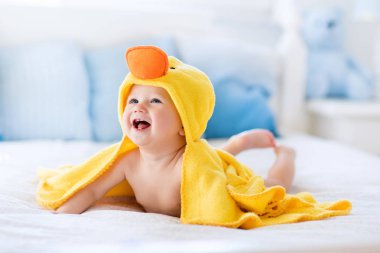 Cute baby after bath in yellow duck towel clipart