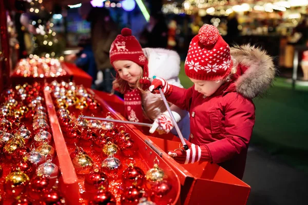 Kinder auf dem Weihnachtsmarkt. Kinder kaufen Weihnachtsgeschenke. — Stockfoto