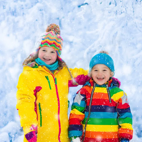 Τα παιδιά παίζουν με το χιόνι το χειμώνα πάρκο — Φωτογραφία Αρχείου