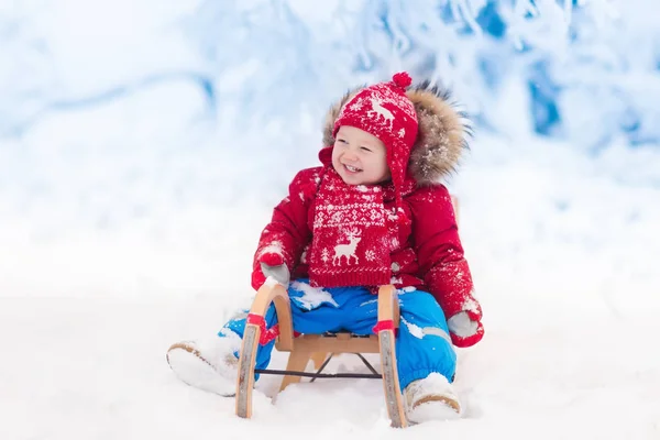 I bambini giocano nella neve. Giro in slitta invernale per bambini — Foto Stock