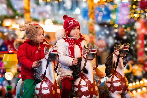 Children riding carousel on Christmas market — Stock Photo, Image