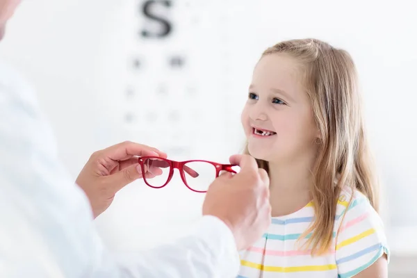 Dziecko o badanie wzroku oka. Dziecko w optitian. Okulary dla dzieci. — Zdjęcie stockowe