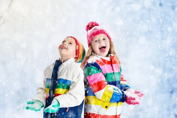 Crianças brincando na neve. Crianças brincam ao ar livre no inverno snowfall . — Fotografia de Stock