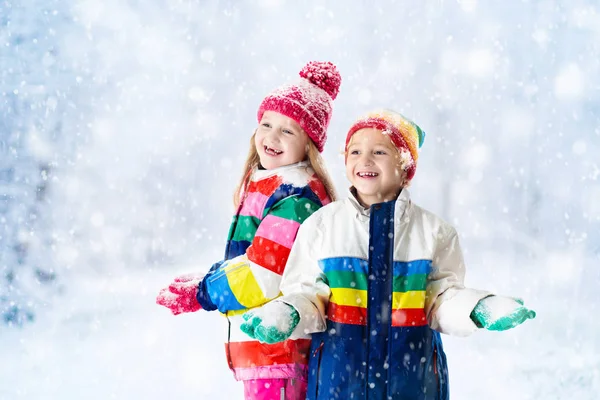 Niños jugando en la nieve. Los niños juegan al aire libre en invierno nevadas . —  Fotos de Stock
