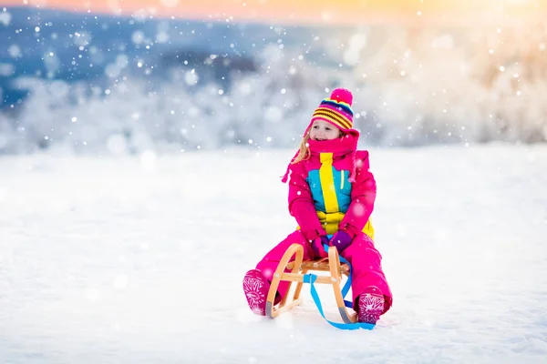 Παιδί που παίζει στο χιόνι στο έλκηθρο στο χειμερινό πάρκο — Φωτογραφία Αρχείου