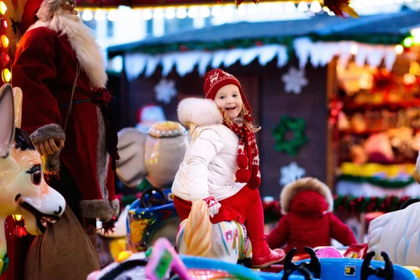 Child on Christmas fair. Kid riding Xmas carousel — Stock Photo, Image