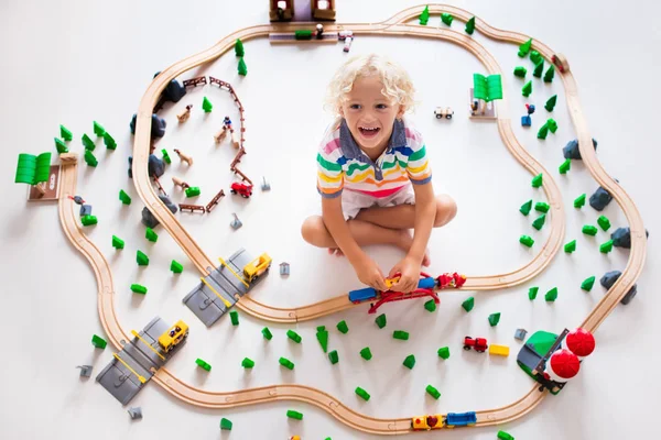 Kind met speelgoed trein. Houten spoorlijn van kinderen. — Stockfoto