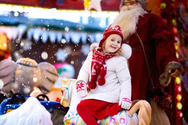 Дитина на Різдвяній ярмарку. Дитяча верхова їзда Різдвяна карусель — стокове фото