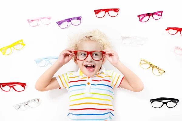 Prueba del niño a la vista. Un chico optimista. Gafas graduadas para niños . — Foto de Stock