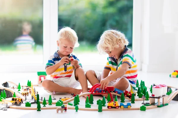 Los niños juegan con el tren de juguete. Ferrocarril de madera . —  Fotos de Stock