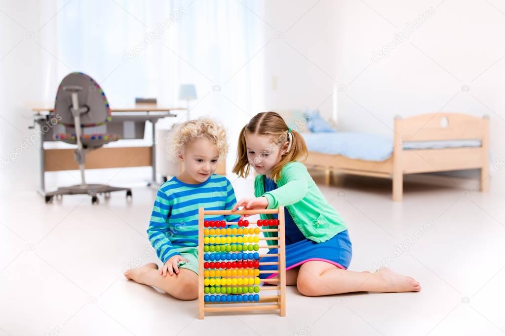 Kids playing with wooden abacus. Educational toy.