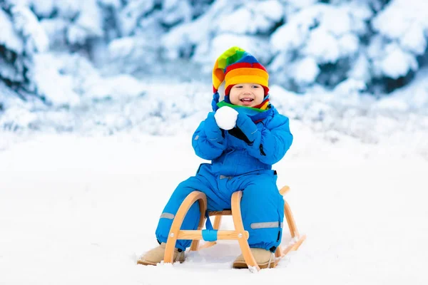 Ragazzo in sella alla slitta. Slitta infantile. Ragazzo con slitta — Foto Stock