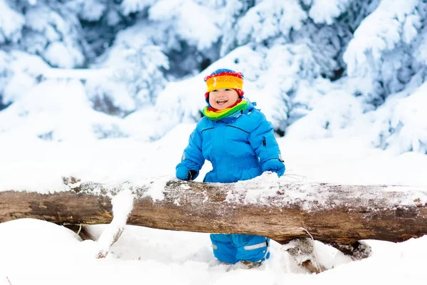 Baby playing with snow in winter. Child in snowy park. — Stock Photo, Image