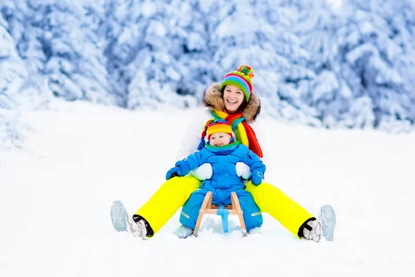 Mother and baby on sleigh ride. Winter snow fun. — Stock Photo, Image