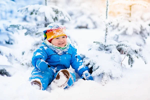 Bébé jouant avec la neige en hiver. Enfant dans un parc enneigé . — Photo