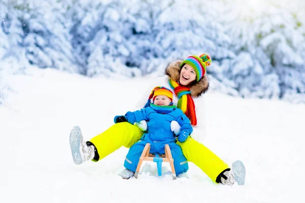 Mother and baby on sleigh ride. Winter snow fun. — Stock Photo, Image