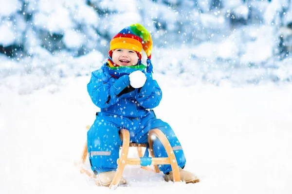 男孩在雪橇上。滑雪橇的孩子。孩子与雪橇 — 图库照片