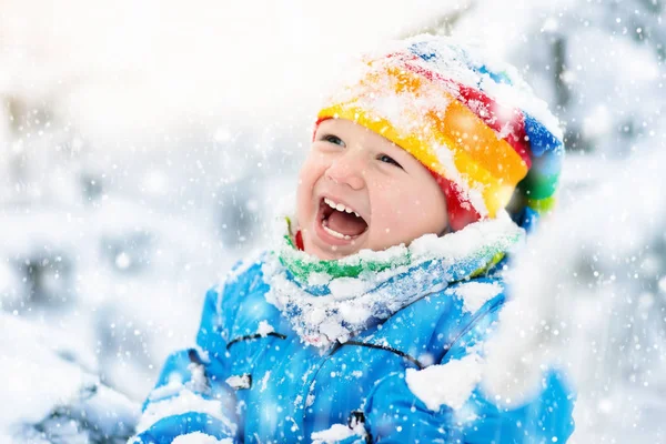 Baby spela med snö på vintern. Barn i snöig park. — Stockfoto