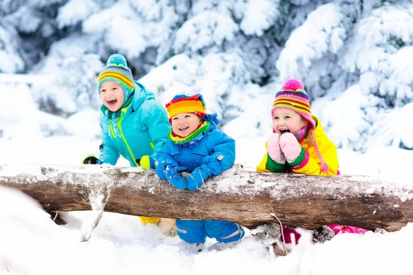 Kids playing in snow. Children play outdoors in winter snowfall.