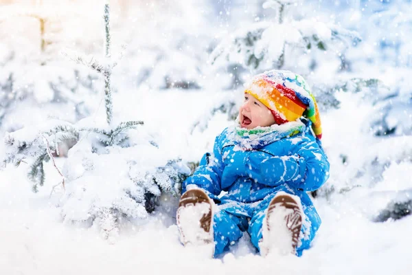 Bebê brincando com neve no inverno. Criança no parque nevado . — Fotografia de Stock