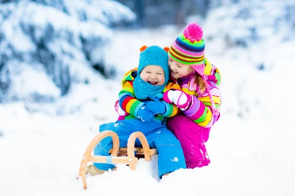 Kinderen op slee rijden. Kinderen rodelen. Sneeuw Winterpret. — Stockfoto