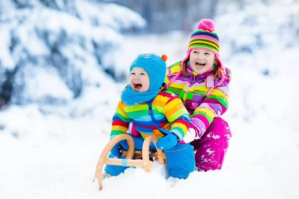 Děti na saních. Děti sáňkování. Zimní radovánky na sněhu. — Stock fotografie