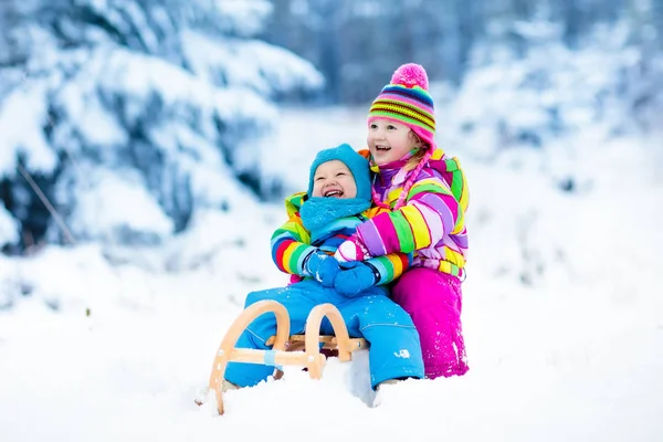 Παιδιά με έλκηθρο που το σέρνουν. Τα παιδιά με έλκηθρο. Διασκέδαση χειμώνα χιόνι. — Φωτογραφία Αρχείου