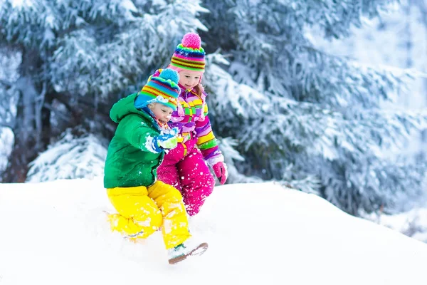 Crianças brincando na neve. Crianças brincam ao ar livre no inverno snowfall . — Fotografia de Stock