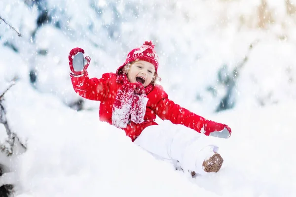 Kind spelen met sneeuw in de winter. Jongen in besneeuwde park. — Stockfoto