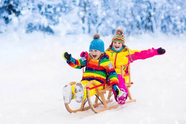 Kinderen spelen in de sneeuw. Winter sleigh ride voor kinderen — Stockfoto