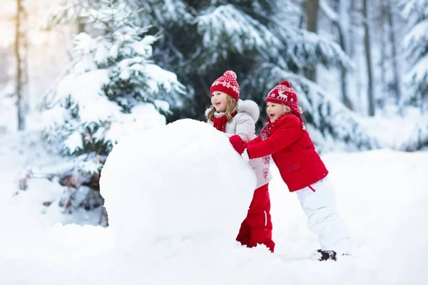 Παιδιά κτίριο χιονάνθρωπος. Τα παιδιά στο χιόνι. Διασκέδαση χειμώνα. — Φωτογραφία Αρχείου