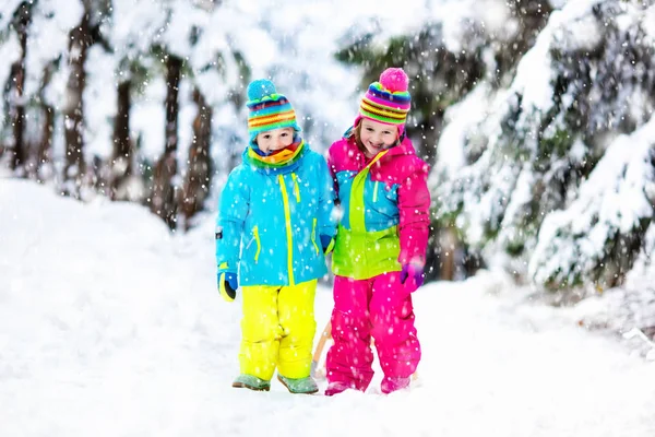 I bambini giocano sulla neve sulla slitta nel parco invernale — Foto Stock