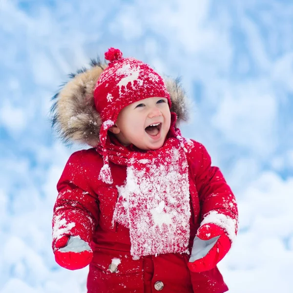 Bébé jouant avec la neige en hiver . — Photo