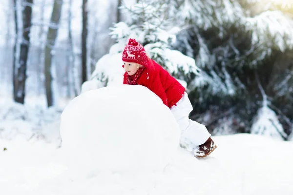 Barnen bygga snögubbe. Barn i snön. Vinternöje. — Stockfoto