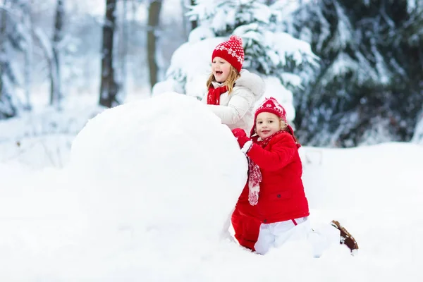 Діти будують сніговика. Діти в снігу. Зимові забави . — стокове фото