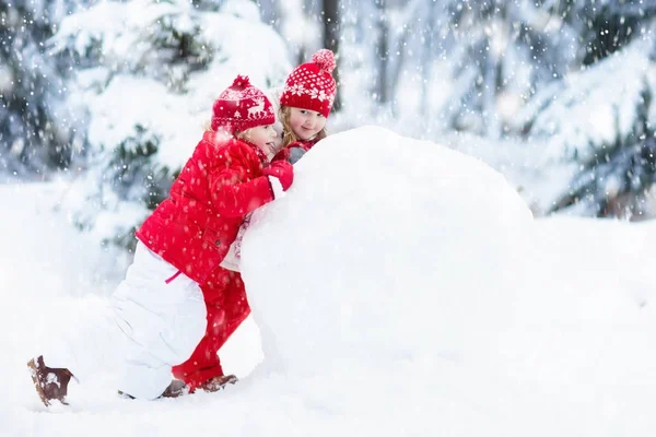 Crianças a construir boneco de neve. Crianças na neve. Diversão de inverno . — Fotografia de Stock