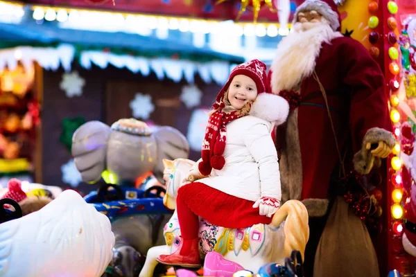 Criança na feira de Natal. Criança montando carrossel de Natal — Fotografia de Stock