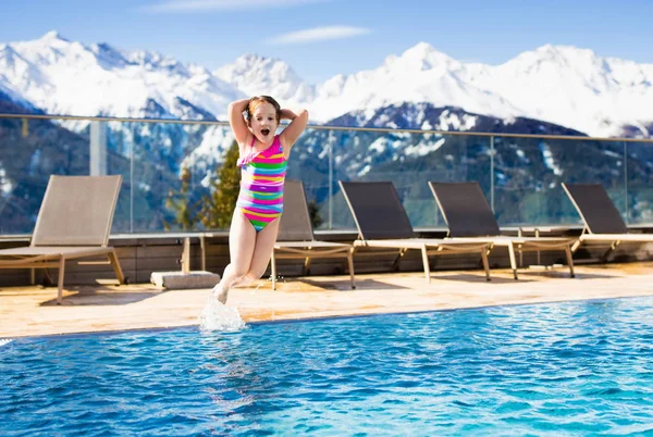 Child in outdoor swimming pool of alpine resort — Stock Photo, Image