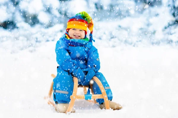 Çocuk kızağı binmek. Kızakla çocuk. Kızak ile çocuk