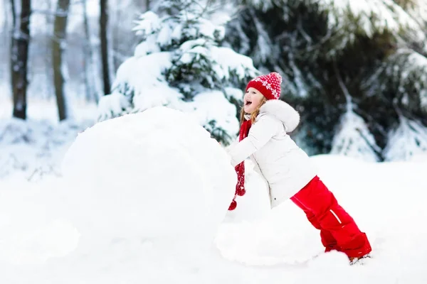 孩子们建设雪人。孩子们在雪地里。冬天的乐趣. — 图库照片