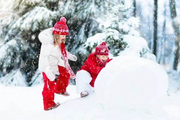 孩子们建设雪人。孩子们在雪地里。冬天的乐趣. — 图库照片