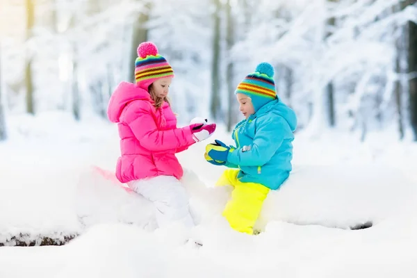 Kids playing in snow. Children play outdoors in winter snowfall.